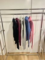 All six sweaters hanging on rack