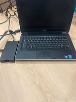 Front view of Dell Latitude E6430 laptop with power adapter brick