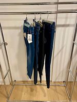 Four pairs of jeans hanging on rack