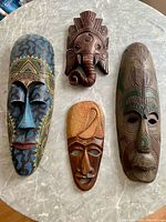 All four wooden masks on marble surface