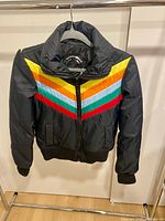 Front view of black puffer coat with multicolour chevron stripes