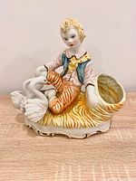 Front view of porcelain planter showing boy, swans and planter opening