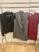 Black blazer, grey dress, red dress hanging on rack