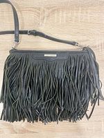 Front view of black leather fringe crossbody with strap