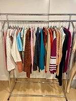 Full rack showing all 23 sweaters in assorted colours