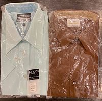 Both shirts in original plastic packaging, side by side
