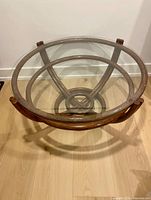 Full view of round coffee table showing glass top and rattan frame