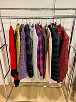 Full rack view showing 13 wool garments on hangers