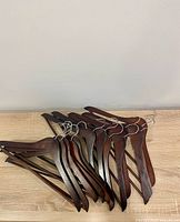 Group of dark wood clothes hangers on wooden surface