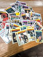 Pile of assorted 1982 NHL hockey cards spread on wooden surface