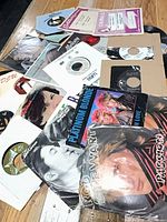 Top view of stack showing several 45 RPM records with picture and generic sleeves