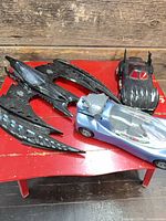 Overview of three Batmobile vehicles on red table