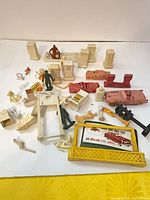 overview of all loose plastic service station playset parts spread on surface