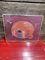 Frontal view of framed animation cel showing characters and frame