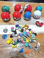 Group showing Poké Balls, pile of figurines, coins