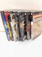 All seven PSP game cases standing upright, spines and partial fronts visible
