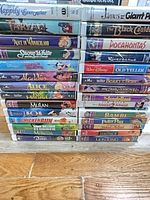 Two stacks of Disney and family VHS tapes showing spines with titles and artwork