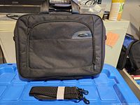 Front view of Toshiba laptop bag showing logo, top handles and front zip pocket