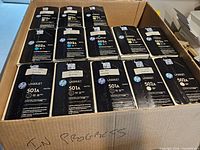 Open box showing multiple sealed HP LaserJet cartridge boxes