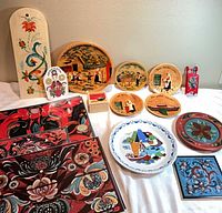 Full lot overview showing placemats, wooden plaques, wood plates, ceramic items