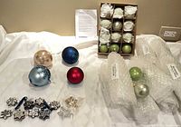 All ornaments displayed: green balls in box and wrap, four large balls, silver star ornaments