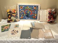 Overview of canvases, yarn bag, fabric cuts, floss binder