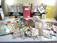 Overview of all paper pads, sticker packs and embellishments spread on table