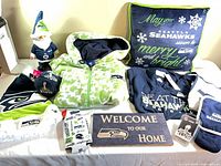Assorted Seahawks apparel, pillow, gnome, sign, kitchen textiles displayed