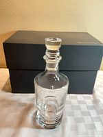 Decanter with stopper in front of padded box