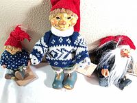 Group shot of three troll dolls showing relative sizes, attire and tags