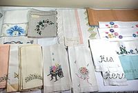 Assortment of embroidered runners and towels laid out