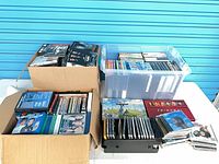 Overview of three containers filled with DVDs, Blu-rays and CDs