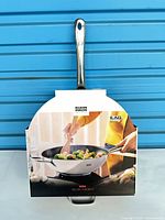 Front view of Kuhn Rikon wok with cardboard sleeve showing prepared stir-fry image