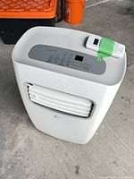 Front and top view of Perfect Aire portable air conditioner with remote placed on top