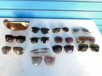 All eleven pairs of sunglasses and gold-tone case displayed on table