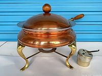 Complete chafing dish assembled with lid on stand and burner alongside