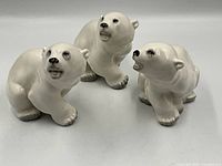 Front view of three porcelain polar bear figurines