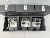 Three open Millennium Collection boxes each holding two crystal flutes with certificates