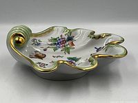 side view showing shell shape, hand-painted motif and gilt rim