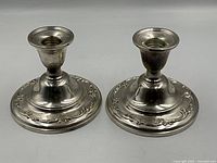 Top view of two sterling candlestick holders showing design and condition