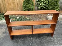 Front view of teak bookcase showing three tiers and central dividers