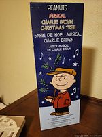 Front of box displaying Peanuts musical Charlie Brown Christmas tree details