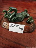 Overall view of jade duck family on wooden base