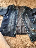 Full view of denim jacket front showing embellishments