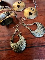 Copper-tone cuff, disc heart earrings, crescent earrings overview