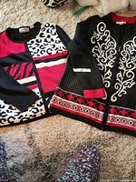 Both sweaters laid out side by side