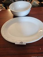 Top view of platter and interior of bowl showing matching white glaze and raised braid rim