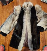 Front view of mink and fox fur coat laid flat
