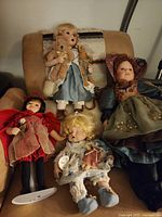 Four porcelain dolls displayed on chair