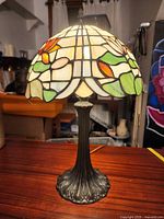 Full view of lamp showing stained glass shade and metal base